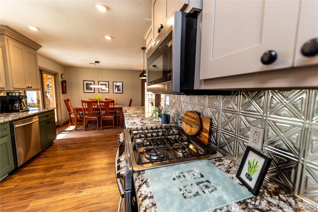 kitchen featuring light hardwood / wood-style floors, a healthy amount of sunlight, hanging light fixtures, and appliances with stainless steel finishes