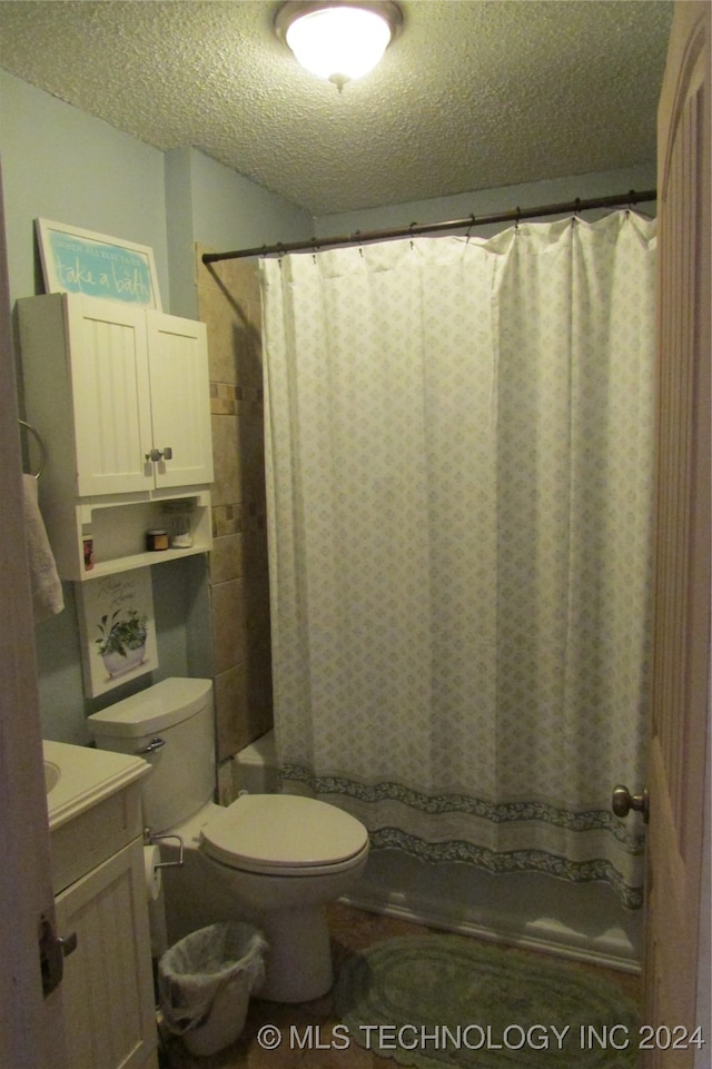 bathroom featuring walk in shower, vanity, a textured ceiling, and toilet