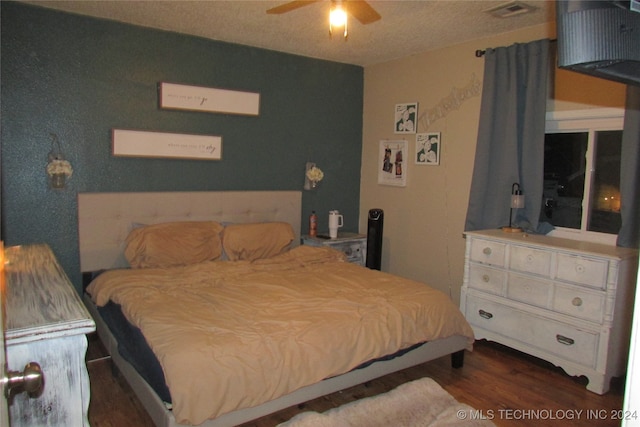 bedroom featuring a textured ceiling, ceiling fan, and dark wood-type flooring