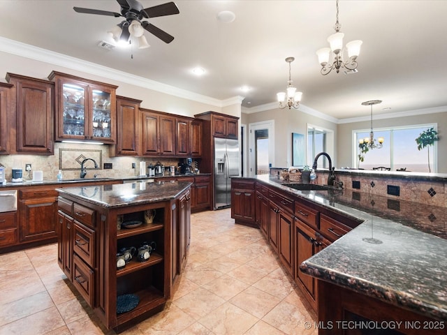 kitchen with sink, decorative light fixtures, stainless steel fridge with ice dispenser, dark brown cabinets, and a kitchen island