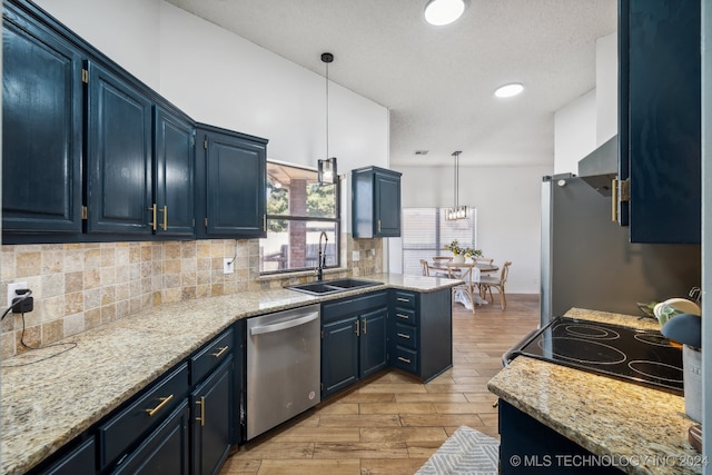 kitchen with stainless steel appliances, blue cabinets, sink, light hardwood / wood-style floors, and hanging light fixtures