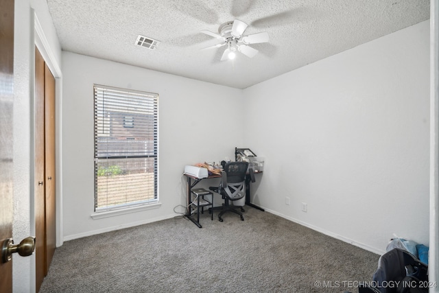 carpeted office featuring ceiling fan and a textured ceiling