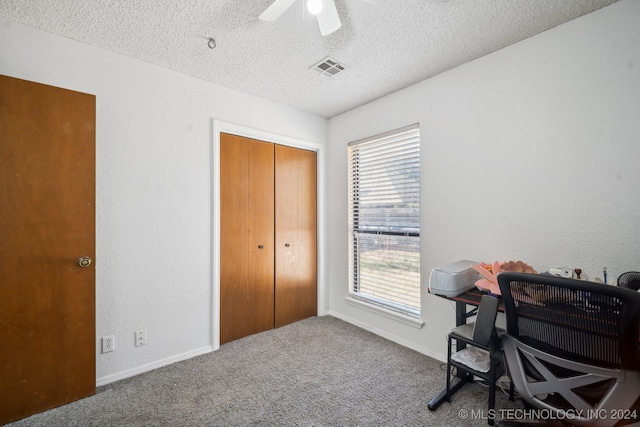 carpeted home office featuring ceiling fan and a textured ceiling