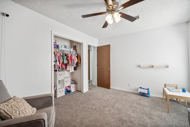 interior space with ceiling fan, a closet, and a textured ceiling