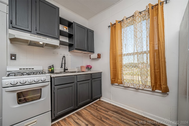 kitchen featuring gray cabinetry, gas range gas stove, sink, dark hardwood / wood-style flooring, and backsplash