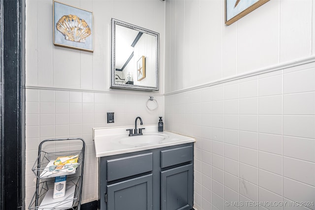 bathroom featuring vanity and tile walls