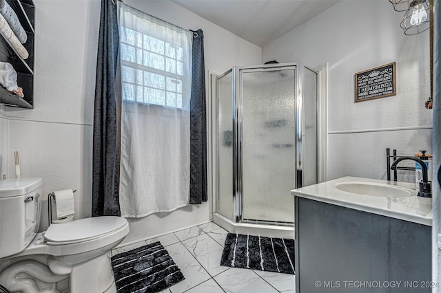 bathroom with vanity, a shower with shower door, a textured ceiling, and toilet