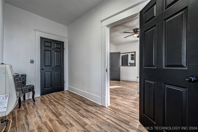 foyer featuring ceiling fan, a textured ceiling, and hardwood / wood-style flooring