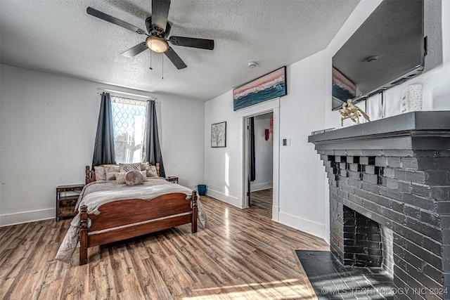 bedroom with ceiling fan, dark wood-type flooring, and a textured ceiling