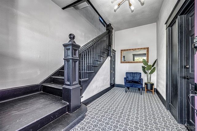 staircase with a textured ceiling