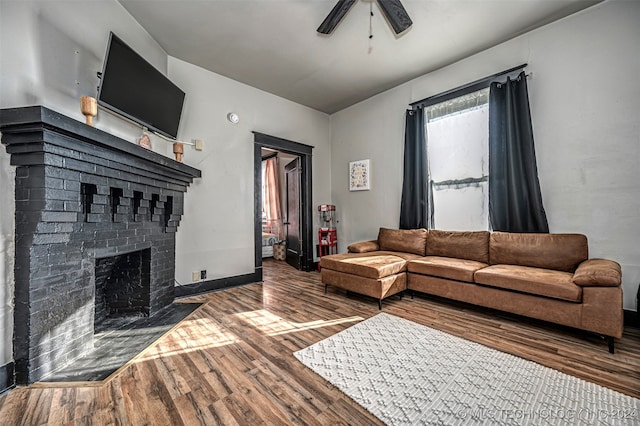 living room featuring a fireplace, wood-type flooring, and ceiling fan