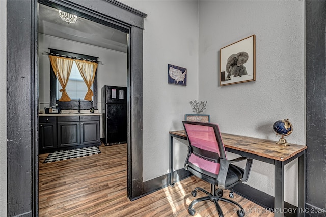 office featuring hardwood / wood-style floors and sink