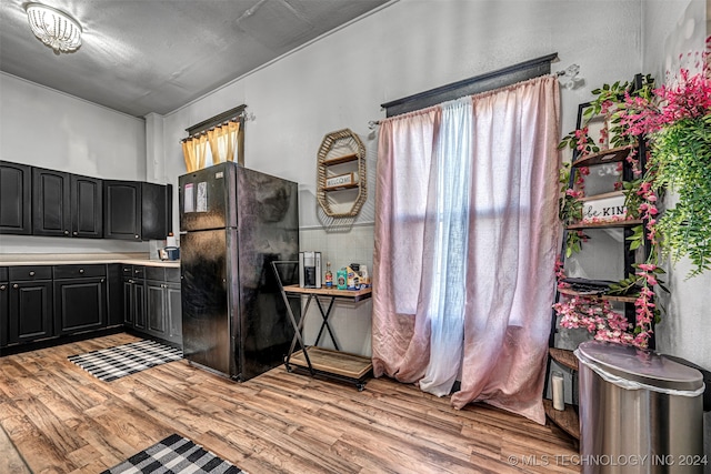 kitchen with black refrigerator and light hardwood / wood-style floors