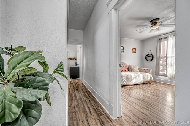 bedroom featuring ceiling fan, a textured ceiling, and hardwood / wood-style flooring