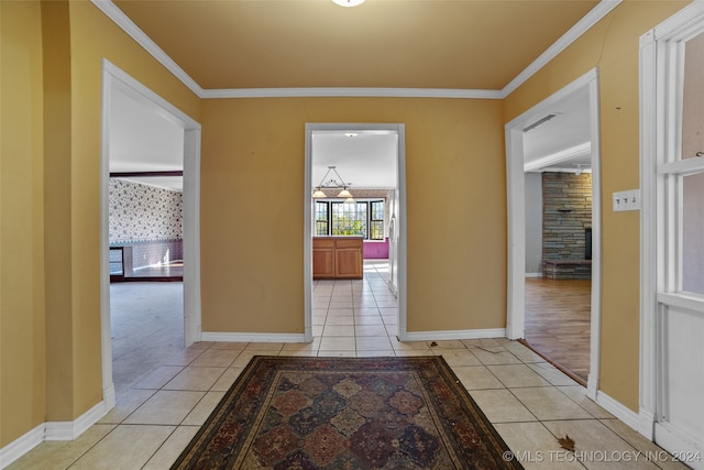 corridor with light tile patterned floors and ornamental molding