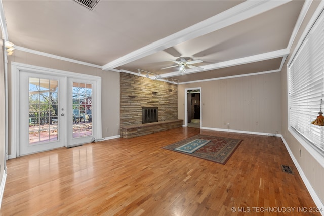 unfurnished living room featuring ceiling fan, a fireplace, beamed ceiling, and hardwood / wood-style flooring