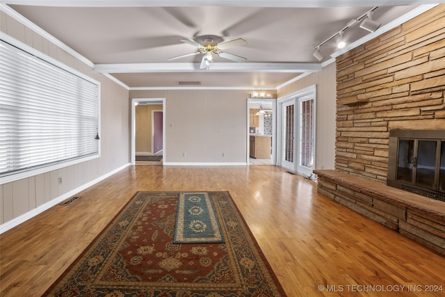 unfurnished living room with a fireplace, hardwood / wood-style floors, rail lighting, and ornamental molding