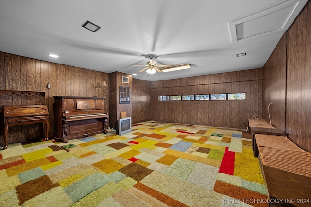 interior space featuring light colored carpet and wooden walls