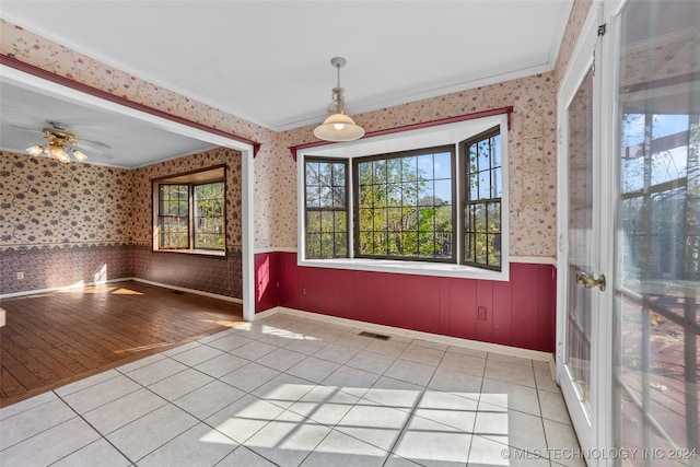 interior space featuring light wood-type flooring, ceiling fan, and ornamental molding