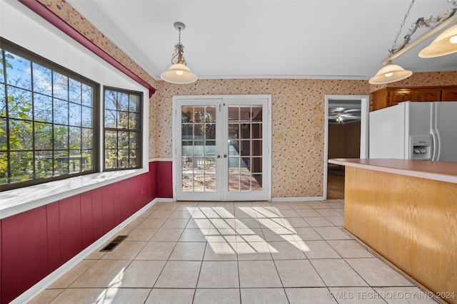 kitchen featuring french doors, crown molding, light tile patterned floors, decorative light fixtures, and white fridge with ice dispenser