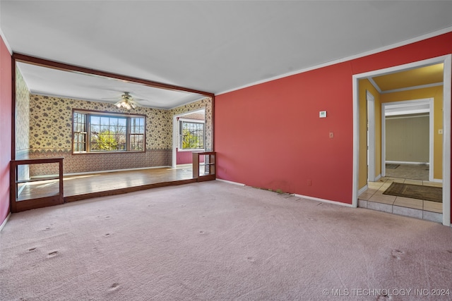 unfurnished room featuring light carpet, ceiling fan, and ornamental molding