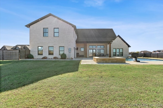 back of house featuring a lawn and a patio