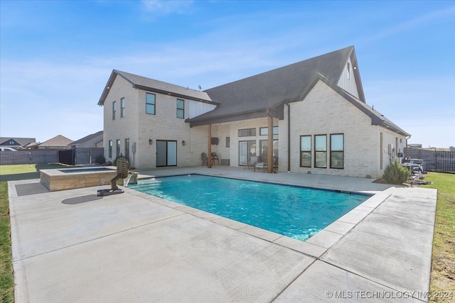 back of property with a patio and a pool with hot tub