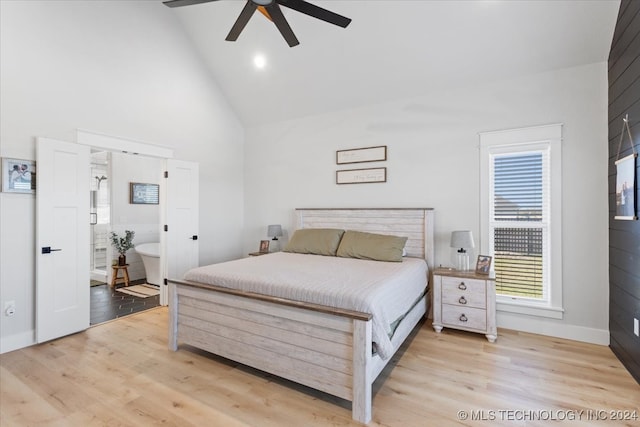 bedroom featuring ensuite bathroom, ceiling fan, high vaulted ceiling, and light wood-type flooring