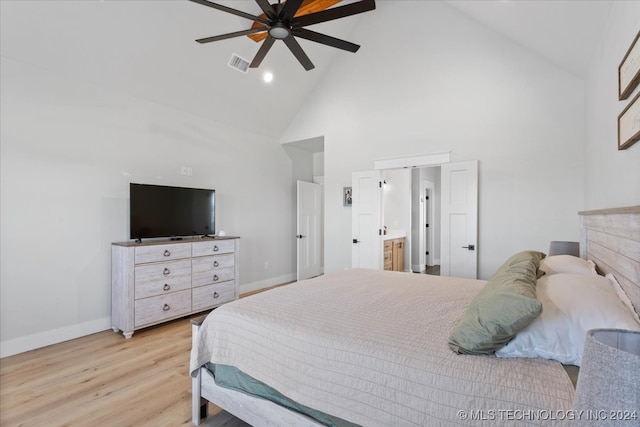 bedroom featuring ceiling fan, ensuite bathroom, high vaulted ceiling, and light hardwood / wood-style floors