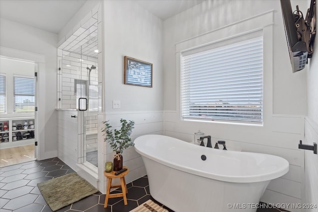 bathroom featuring separate shower and tub, tile patterned flooring, and a healthy amount of sunlight