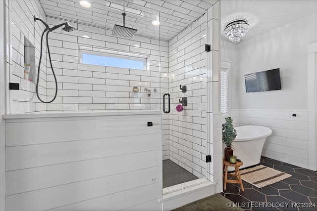 bathroom featuring a chandelier and shower with separate bathtub