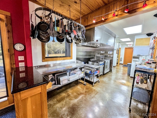 kitchen with kitchen peninsula, decorative light fixtures, high end stainless steel range, and wood ceiling