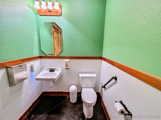 bathroom featuring tile patterned flooring, toilet, and sink