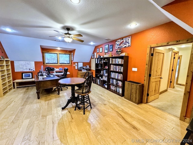 office with ceiling fan, lofted ceiling, a textured ceiling, and light hardwood / wood-style flooring