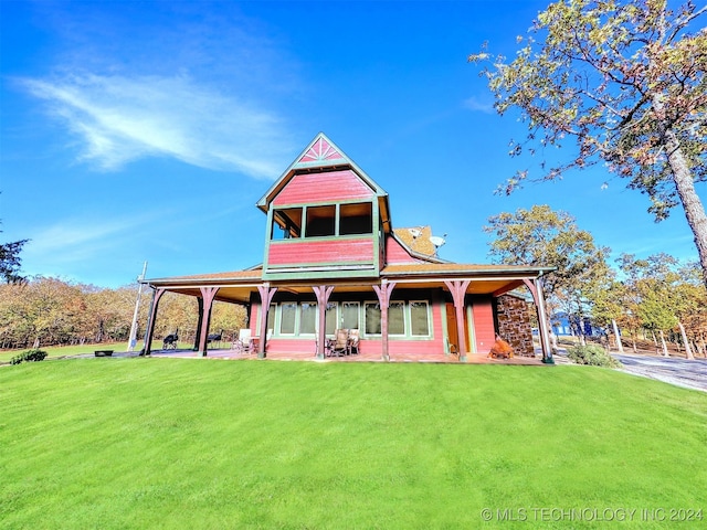 rear view of property with a lawn