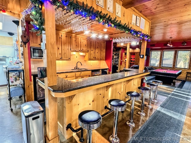 bar featuring tasteful backsplash, sink, wooden ceiling, stainless steel microwave, and pool table