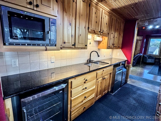 kitchen with stainless steel microwave, sink, wine cooler, dark tile patterned floors, and black dishwasher