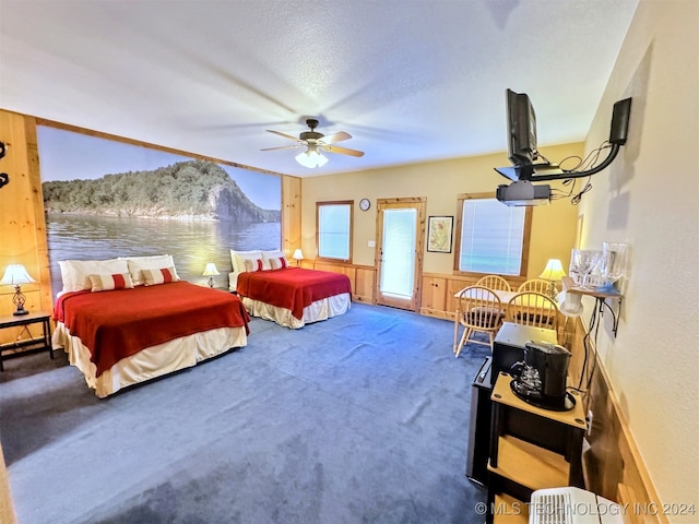 carpeted bedroom with ceiling fan and a textured ceiling