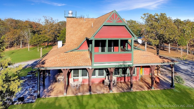 back of property with a patio area and a yard