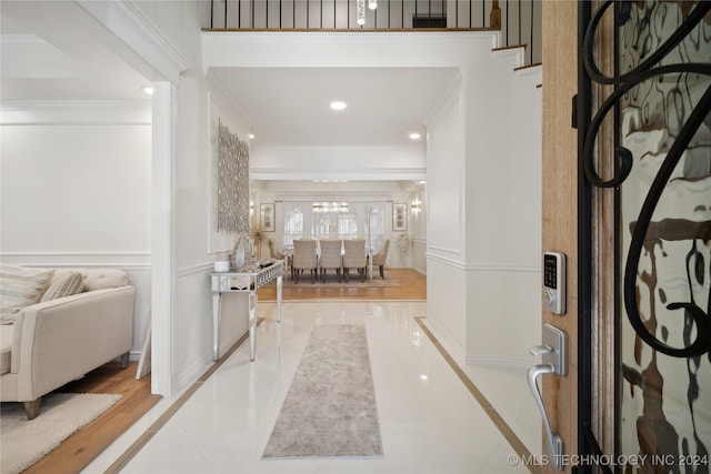 entrance foyer with light tile patterned floors and ornamental molding