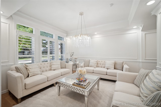 living room featuring an inviting chandelier, ornamental molding, and hardwood / wood-style flooring