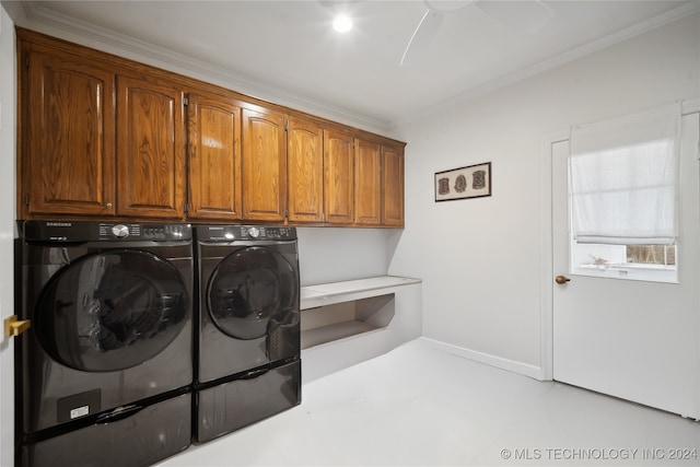 washroom featuring washing machine and dryer, cabinets, and ornamental molding