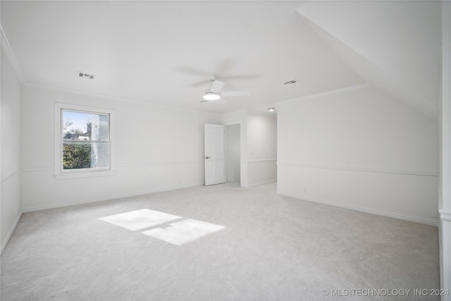 spare room featuring ceiling fan, light colored carpet, lofted ceiling, and ornamental molding