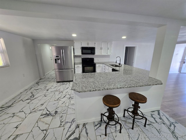 kitchen with black appliances, white cabinetry, kitchen peninsula, and a healthy amount of sunlight