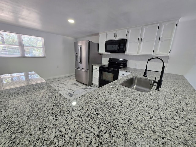 kitchen with black appliances, white cabinets, sink, tasteful backsplash, and light stone counters