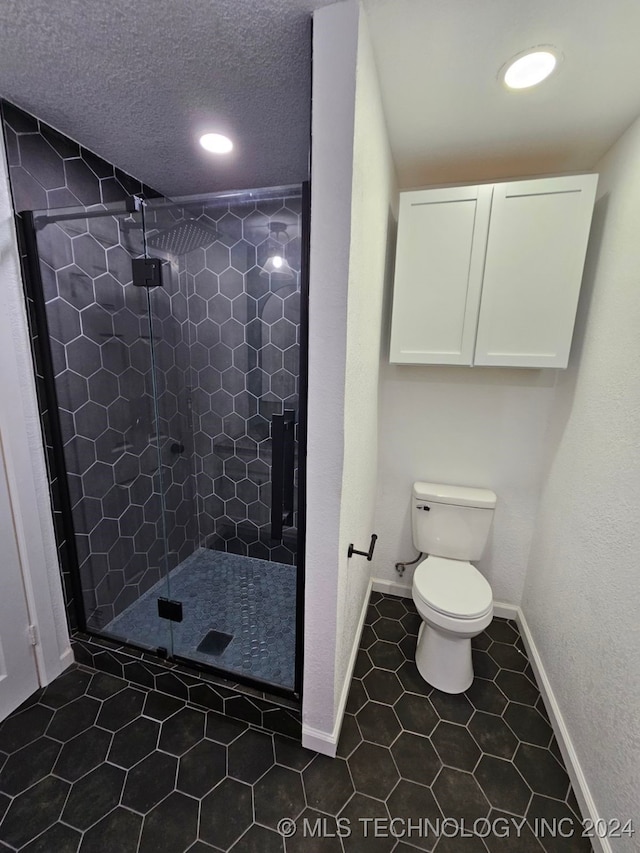 bathroom with tile patterned flooring, toilet, and walk in shower