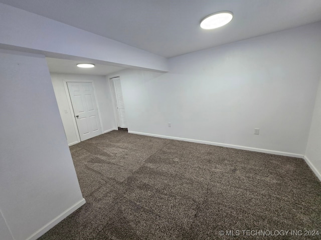 unfurnished room featuring dark carpet