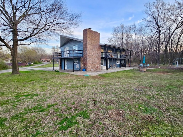 view of side of home with a patio area and a yard