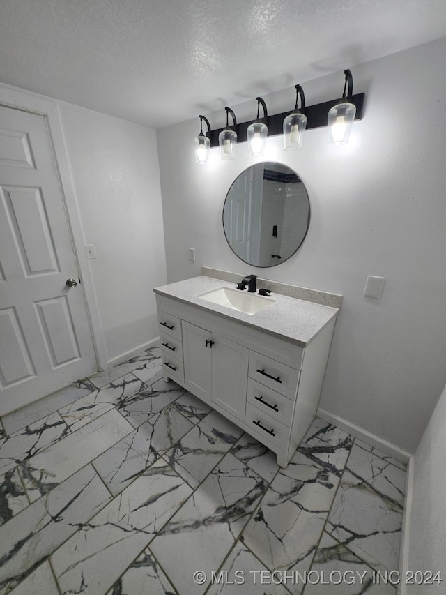 bathroom featuring a textured ceiling and vanity