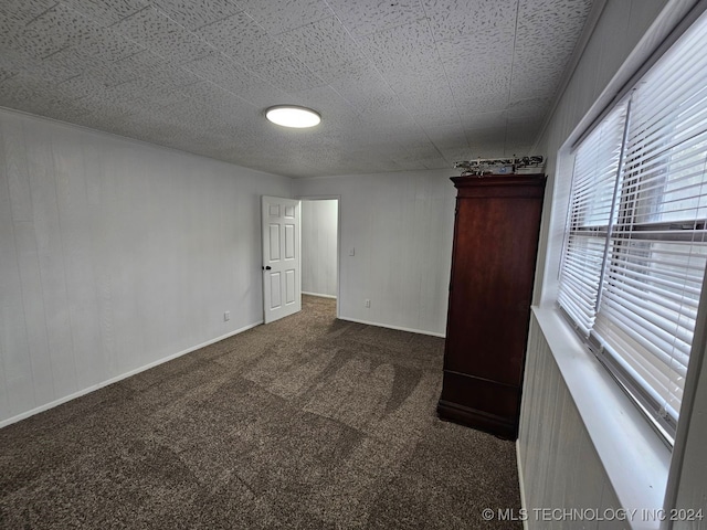 unfurnished bedroom featuring dark carpet